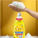 Lavalozas Magistral Limón 500ml — mano con espuma sobre la botella en fondo amarillo con fórmula concentrada aroma limón para loza diaria